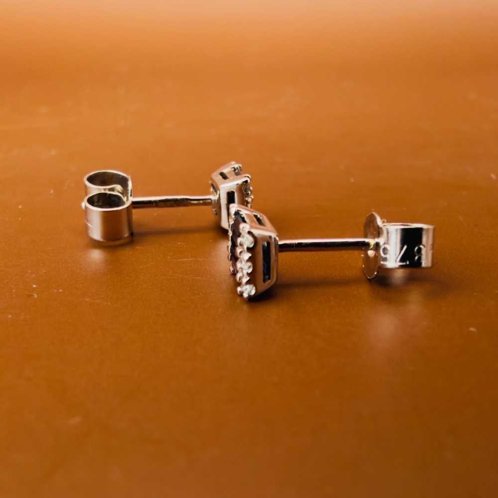 A pair of 9ct white gold stud earrings featuring two central emerald-cut blue sapphires flanked by small round diamonds. View VIII