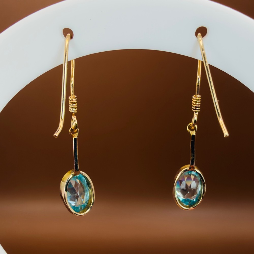 A pair of 9ct yellow gold Art Deco drop earrings featuring oval-cut light blue zircons suspended from vertical gold bars and shepherd hook wires. View VIII