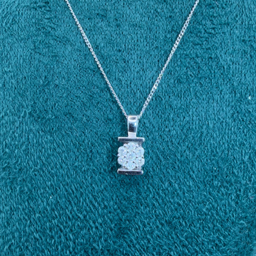 A white gold jewellery set consisting of a fine chain necklace with a round diamond cluster pendant and matching cluster stud earrings. View III