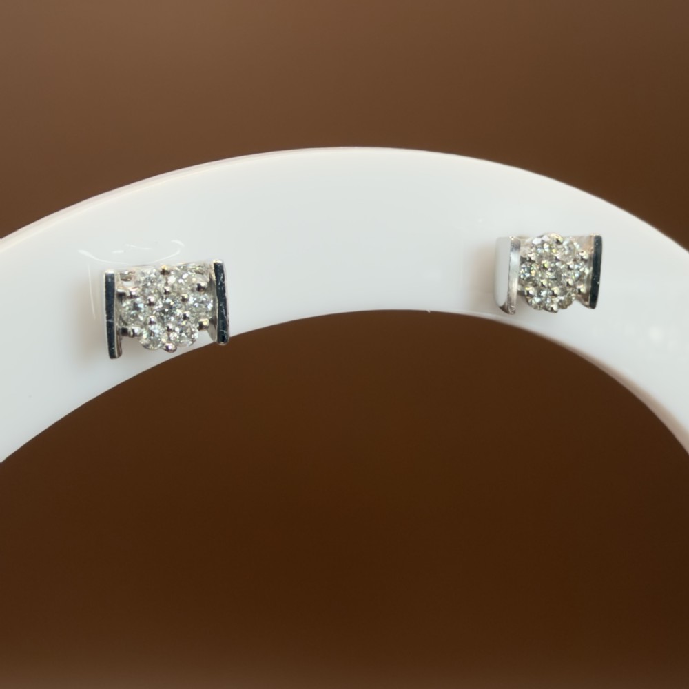 A white gold jewellery set consisting of a fine chain necklace with a round diamond cluster pendant and matching cluster stud earrings. View VII