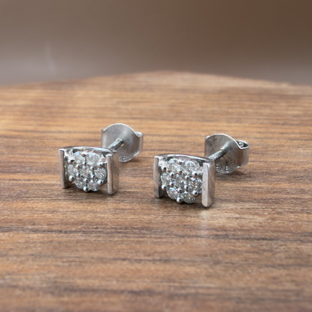 A white gold jewellery set consisting of a fine chain necklace with a round diamond cluster pendant and matching cluster stud earrings. View VIII