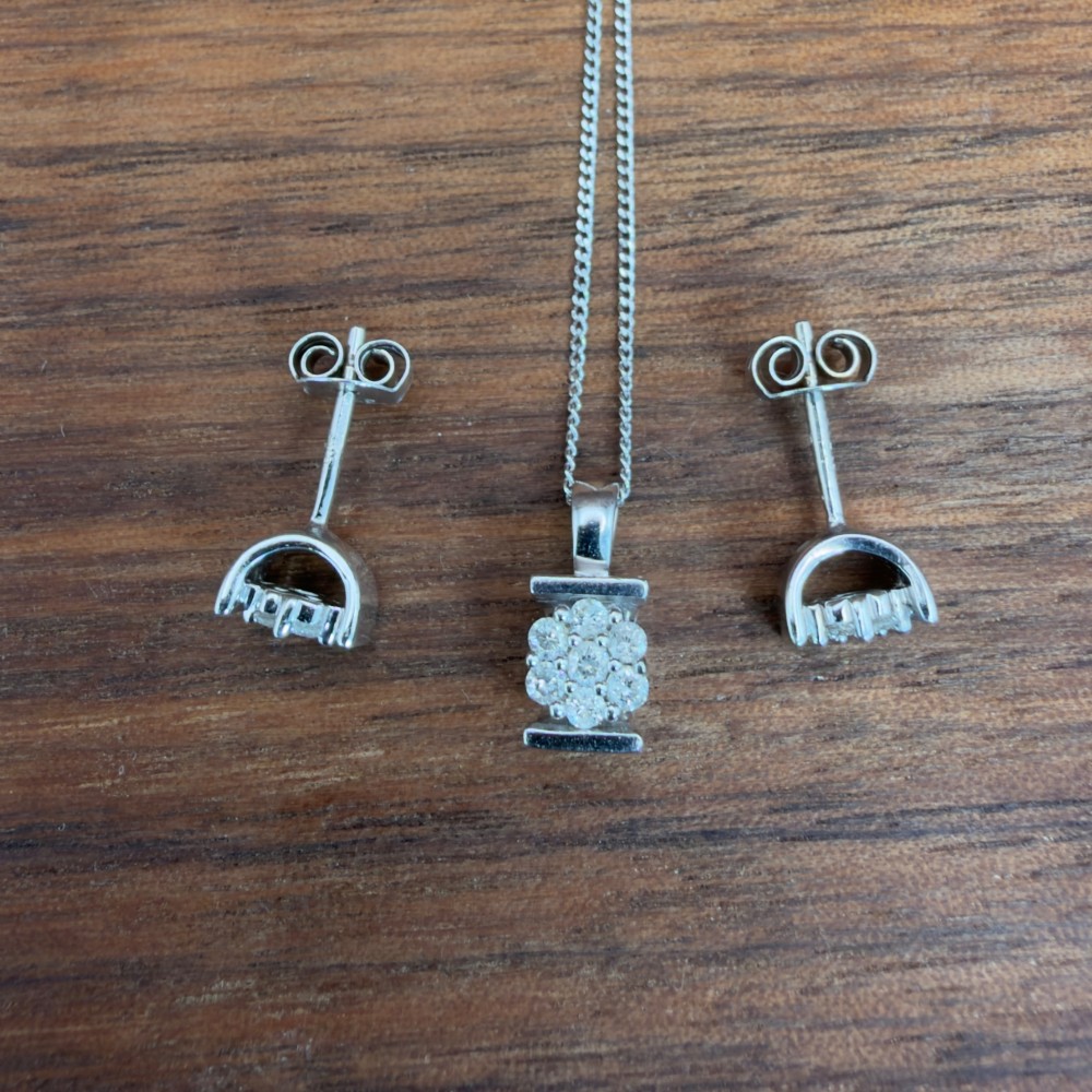 A white gold jewellery set consisting of a fine chain necklace with a round diamond cluster pendant and matching cluster stud earrings. View IX
