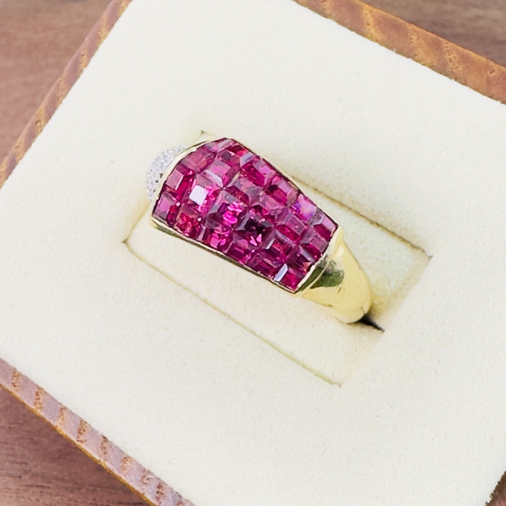An 18ct yellow gold dress ring featuring a curved panel of princess cut red rubies alongside diamond set shoulders. View III