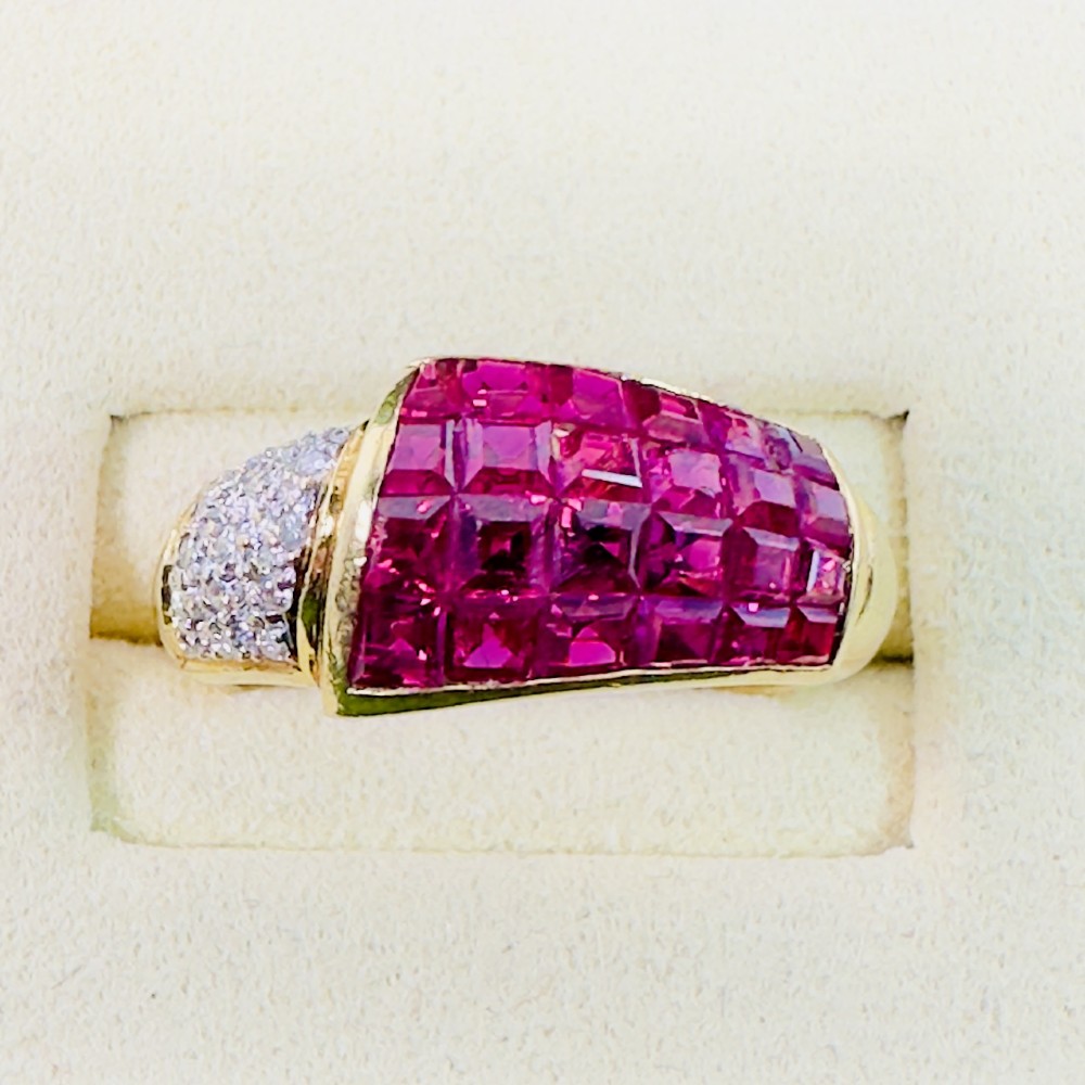 An 18ct yellow gold dress ring featuring a curved panel of princess cut red rubies alongside diamond set shoulders. View V