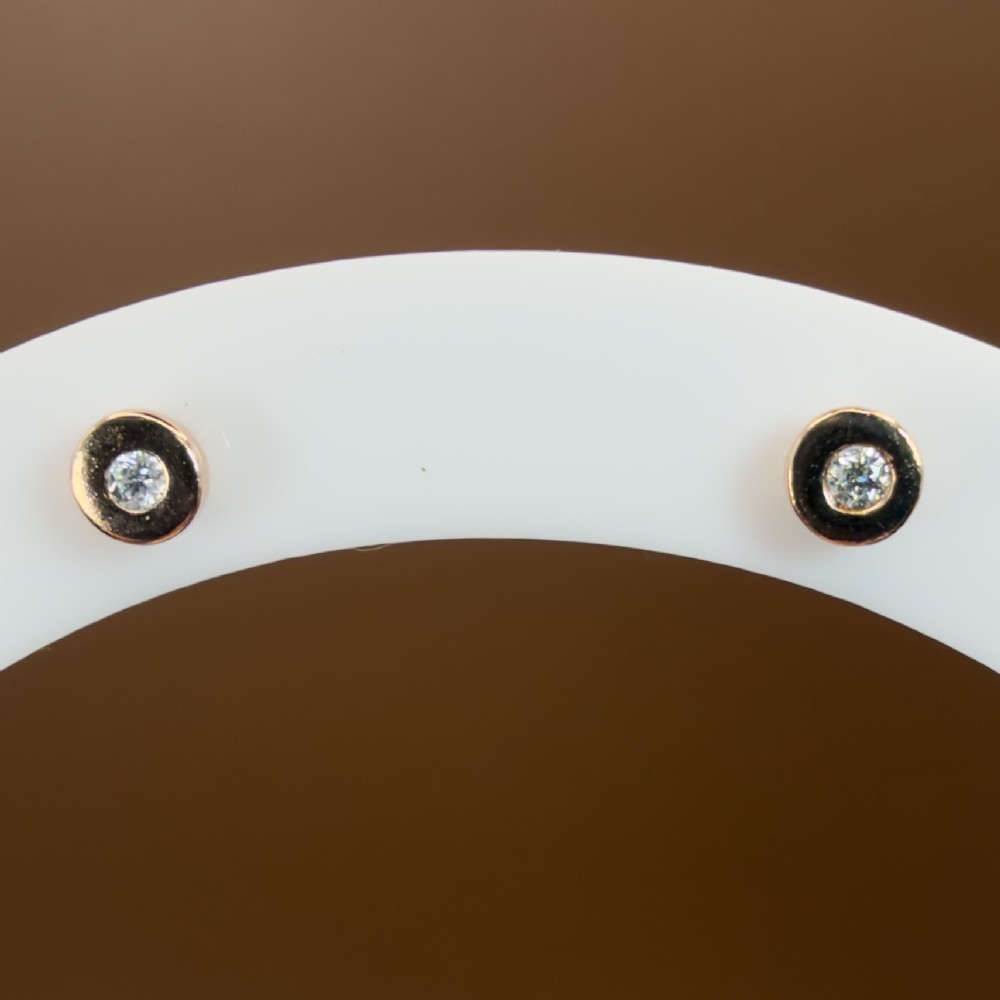 A pair of circular 9ct rose gold stud earrings featuring round bezel-set natural diamonds. View V