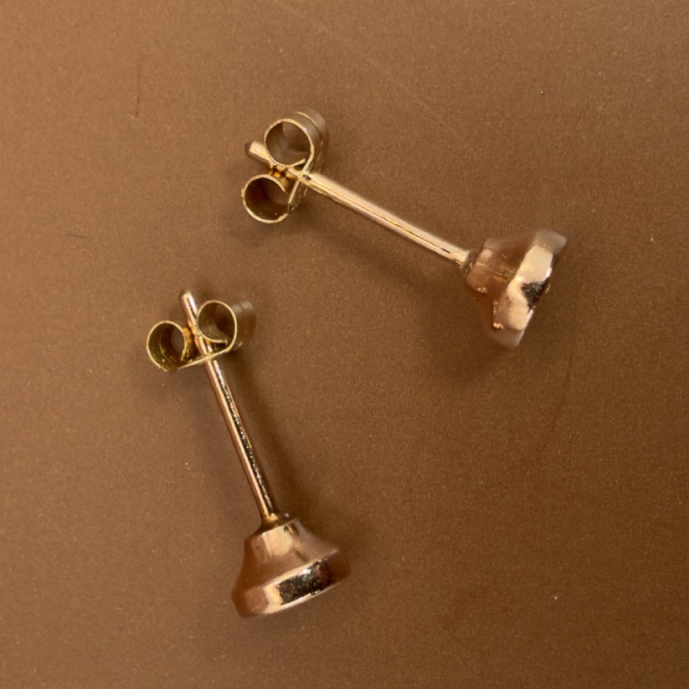 A pair of circular 9ct rose gold stud earrings featuring round bezel-set natural diamonds. View XI