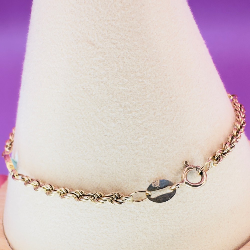 A 9ct yellow gold rope chain bracelet featuring oval bezel-set light blue topaz gemstones at spaced intervals. View VIII