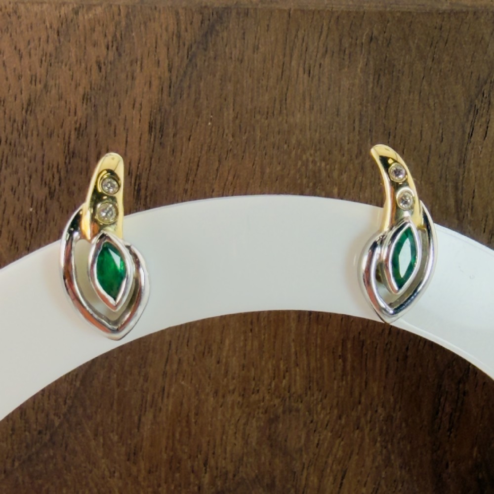 A pair of two-tone 14ct gold stud earrings set with marquise-cut green emeralds and small round diamonds. View IV