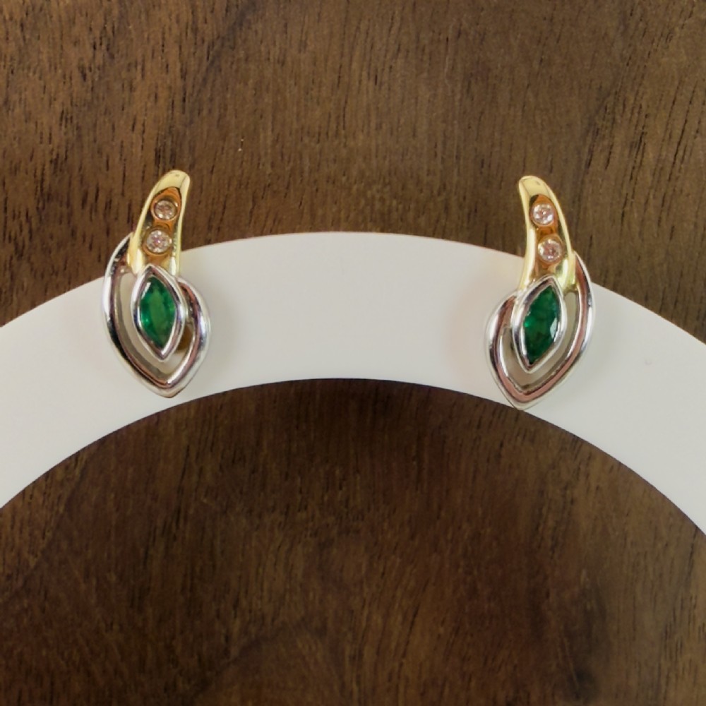A pair of two-tone 14ct gold stud earrings set with marquise-cut green emeralds and small round diamonds. View VI