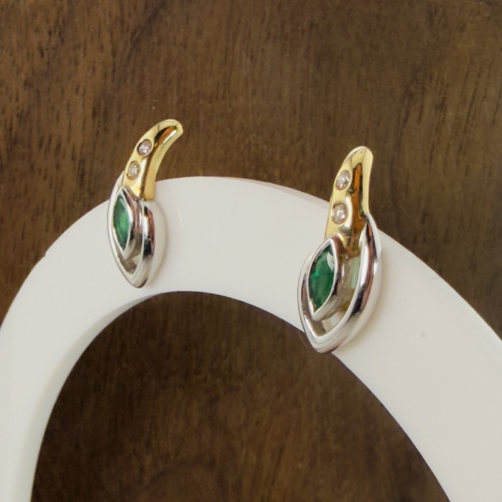 A pair of two-tone 14ct gold stud earrings set with marquise-cut green emeralds and small round diamonds. View VII