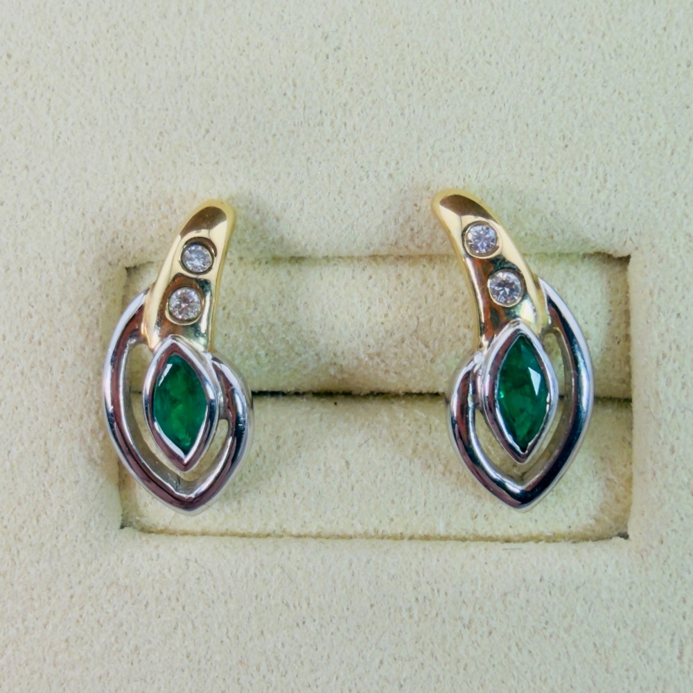 A pair of two-tone 14ct gold stud earrings set with marquise-cut green emeralds and small round diamonds. View X