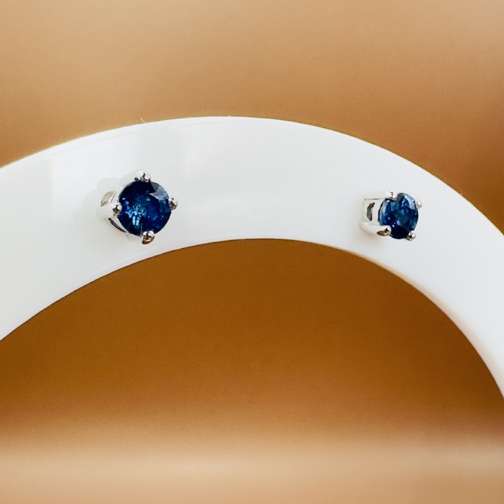 A pair of round-cut blue sapphire stud earrings set in four-claw 18ct white gold mounts. View IV