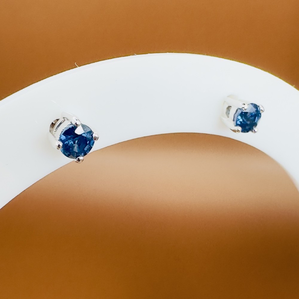 A pair of round-cut blue sapphire stud earrings set in four-claw 18ct white gold mounts. View V