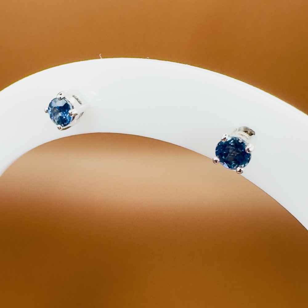 A pair of round-cut blue sapphire stud earrings set in four-claw 18ct white gold mounts. View VI