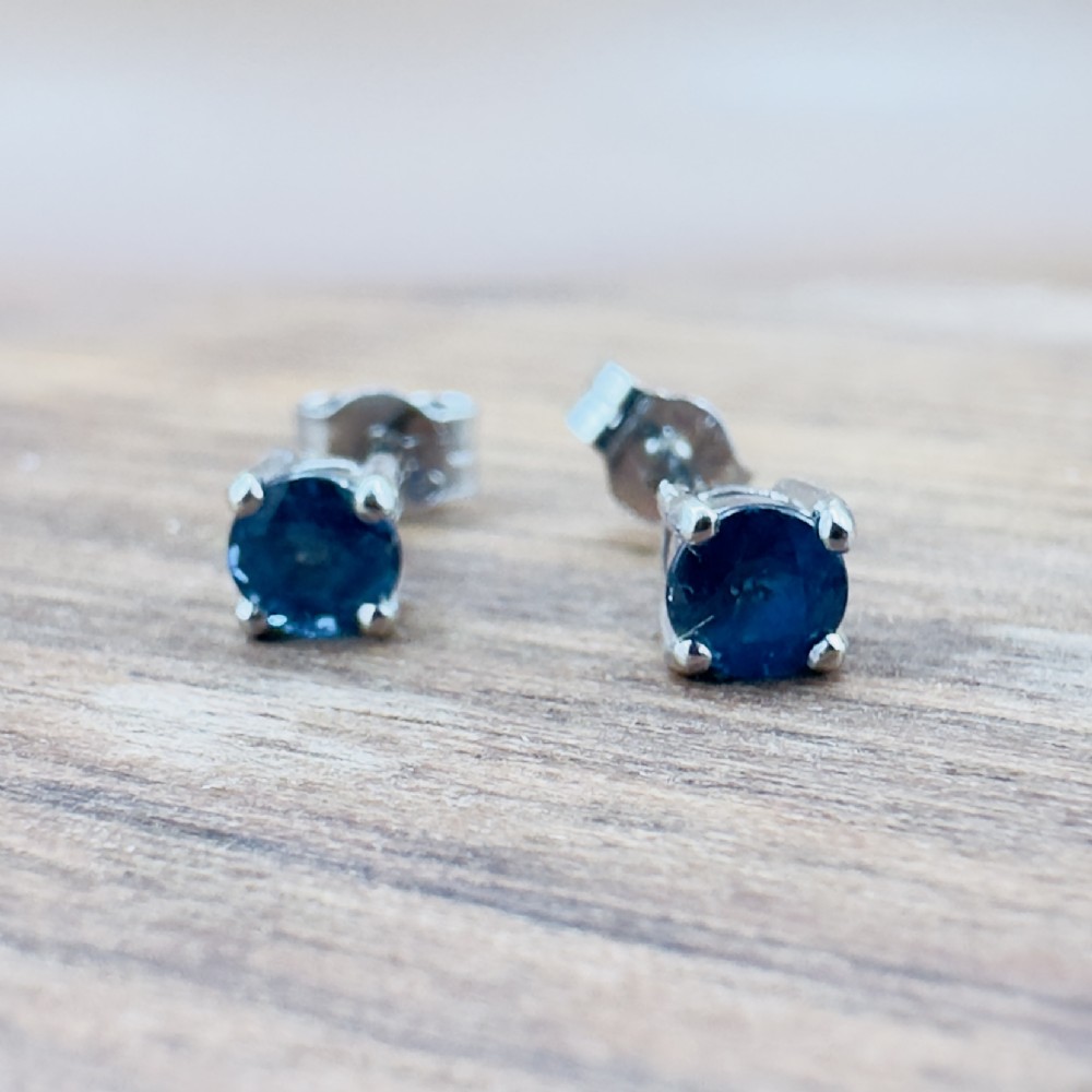 A pair of round-cut blue sapphire stud earrings set in four-claw 18ct white gold mounts. View VII