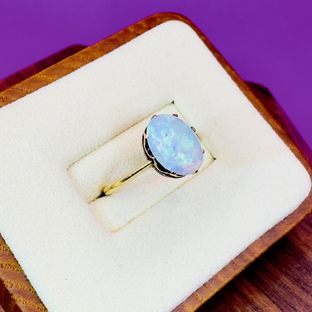 An 18ct yellow gold Victorian solitaire ring featuring an oval cabochon opal in a claw setting. View IV