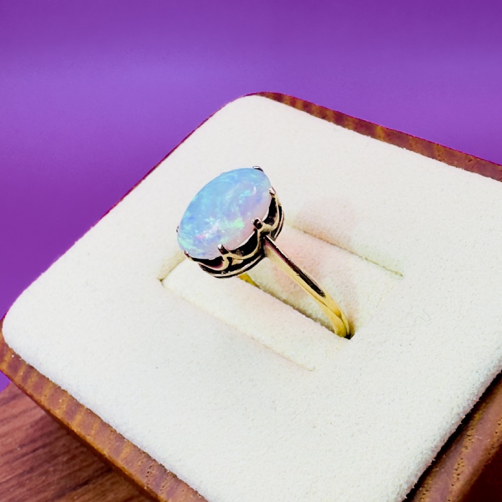 An 18ct yellow gold Victorian solitaire ring featuring an oval cabochon opal in a claw setting. View VI