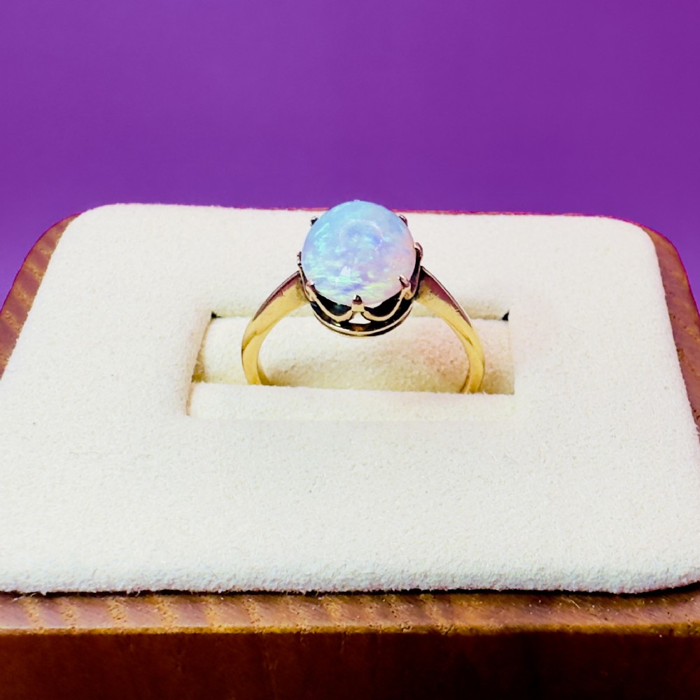 An 18ct yellow gold Victorian solitaire ring featuring an oval cabochon opal in a claw setting. View VII