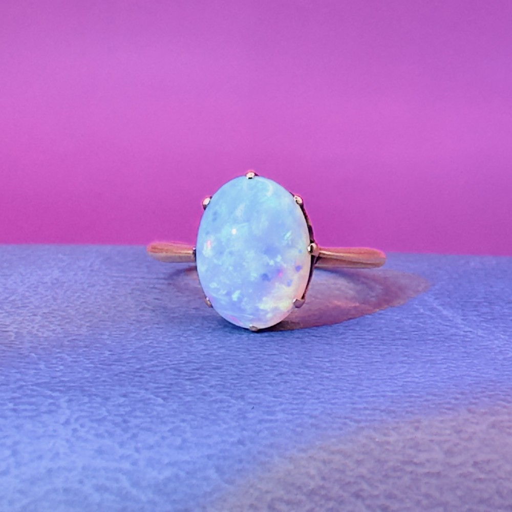 An 18ct yellow gold Victorian solitaire ring featuring an oval cabochon opal in a claw setting. View X