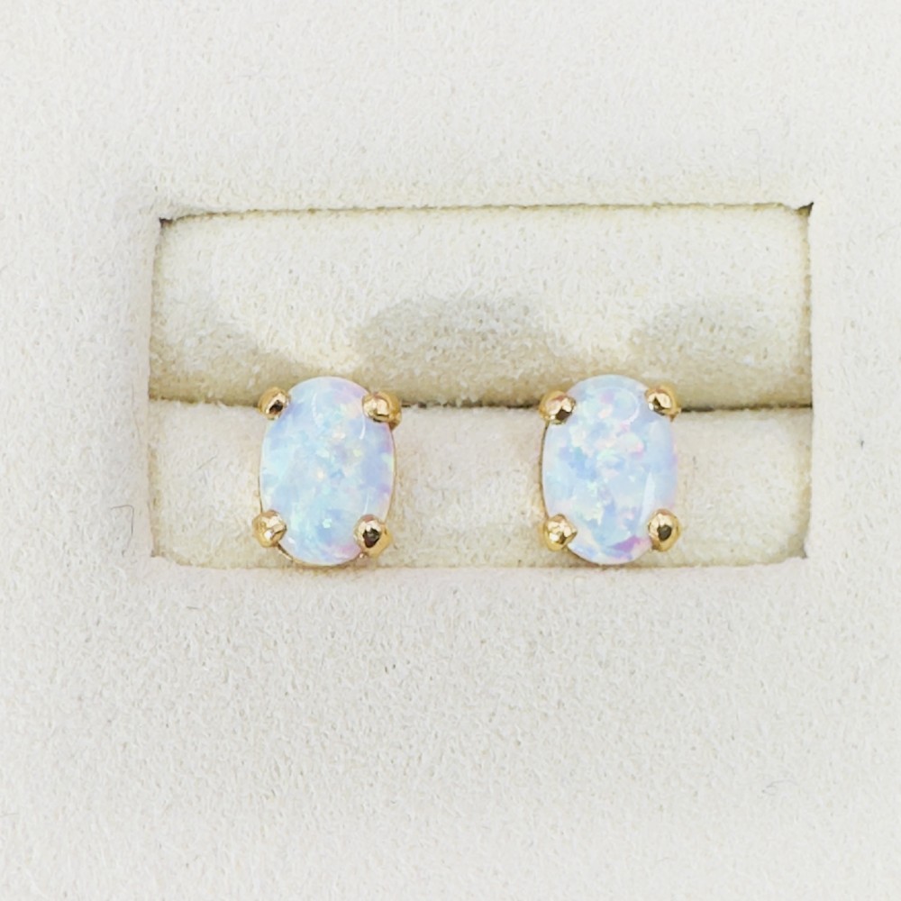 A pair of 14ct yellow gold stud earrings featuring oval-cut white opals held in four-claw settings. View II