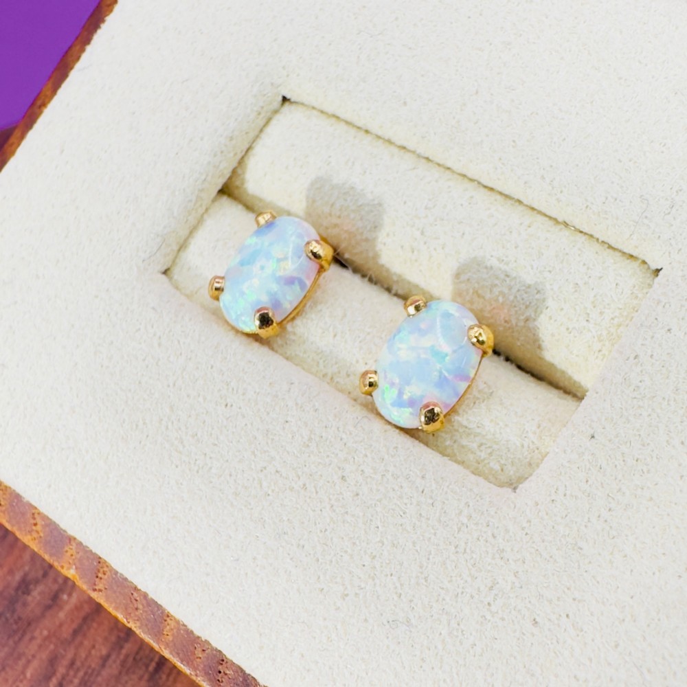 A pair of 14ct yellow gold stud earrings featuring oval-cut white opals held in four-claw settings. View III