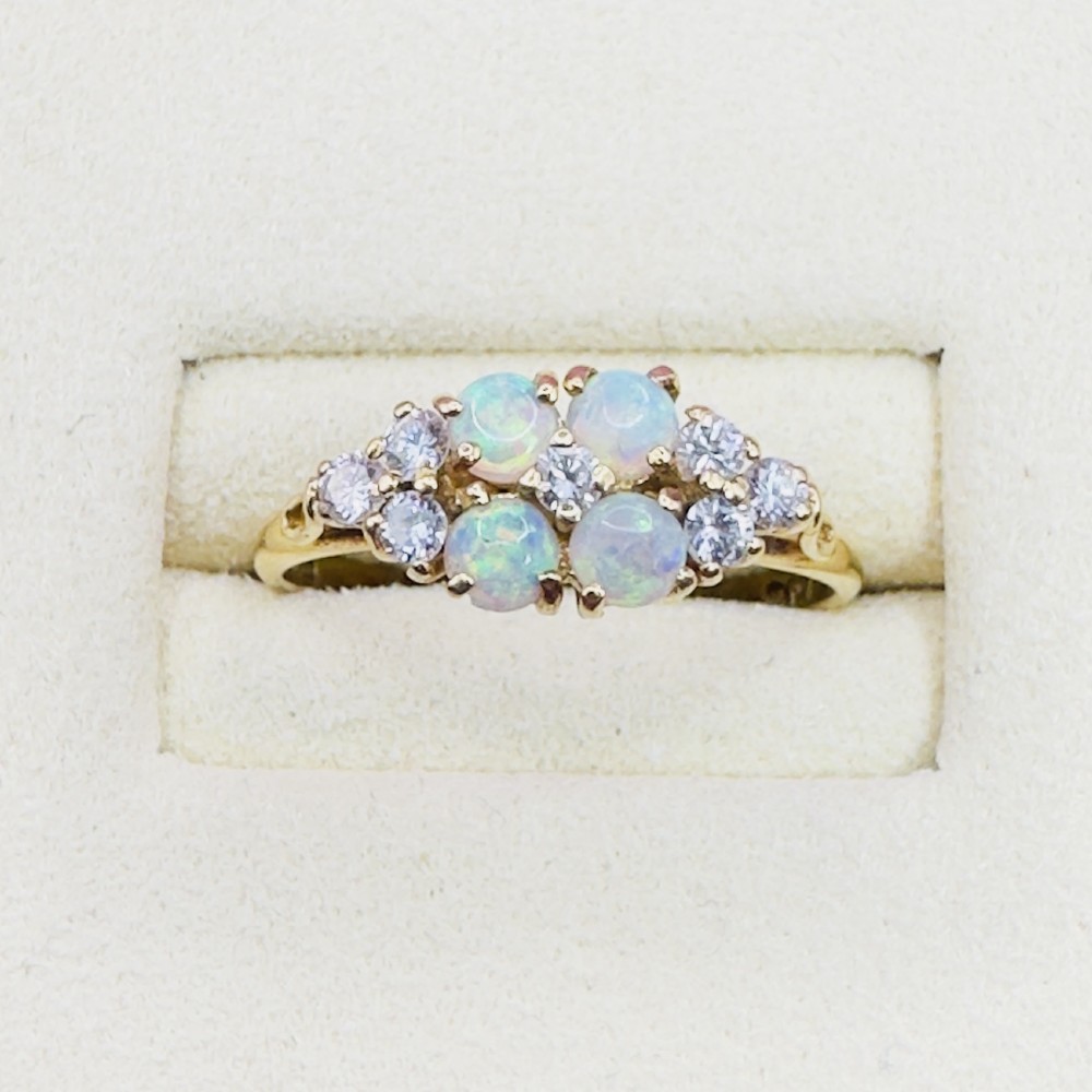 An 18ct yellow gold cluster ring set with four round cabochon opals centrally and flanked by small diamonds. View II