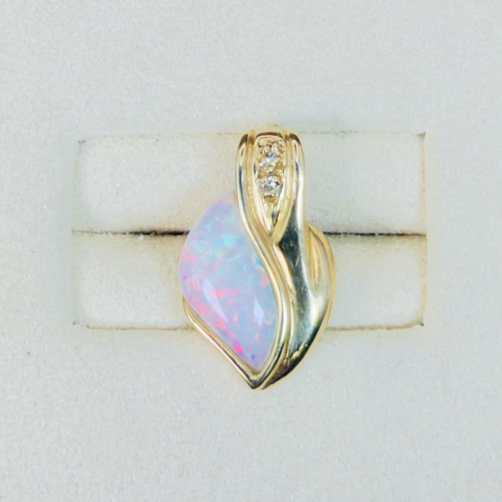 An 18ct yellow gold freeform pendant displaying an iridescent white opal with green and pink flash, set alongside two accent diamonds on the bail. View IV