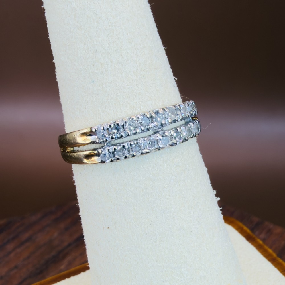An 18ct yellow gold ring featuring a double row band set with round diamonds across the top half. View VI