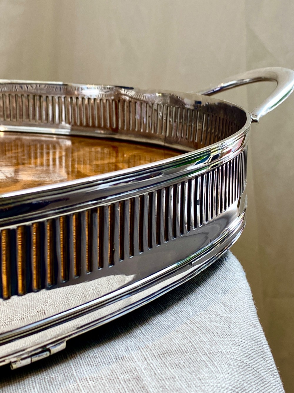 An oval 19th-century quarter-sawn oak gallery tray featuring a pierced silver-plated rim, central engraved shield plaque, and side carrying handles. View VI