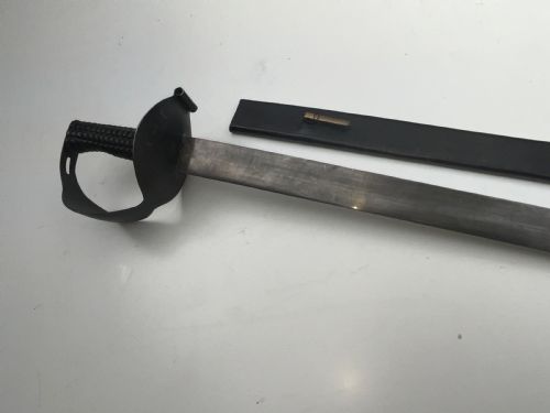 fig 4. A British 1804 pattern naval boarding cutlass featuring a black figure-eight iron handguard and a straight single-edged steel blade.