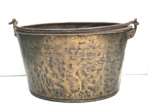 A tapered Georgian copper pan with a hand-hammered surface and a wrought iron rim with side handles.