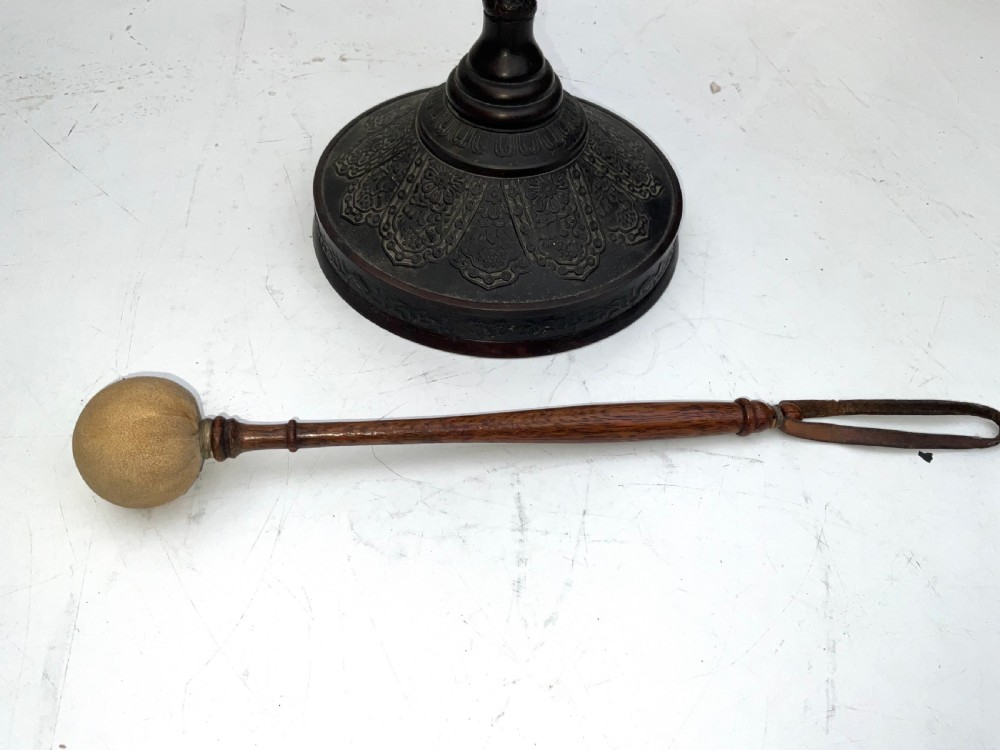 A Victorian dark bronze tabletop dinner gong featuring relief carving and a sculpted figure mounted atop a circular pedestal base. View III