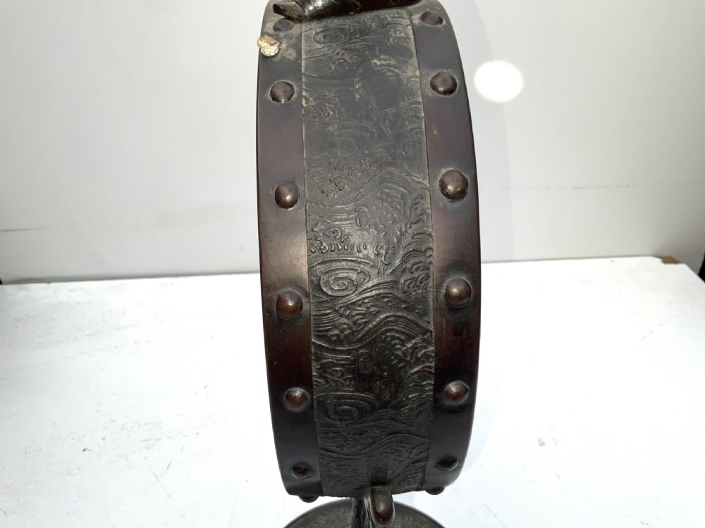 A Victorian dark bronze tabletop dinner gong featuring relief carving and a sculpted figure mounted atop a circular pedestal base. View VI
