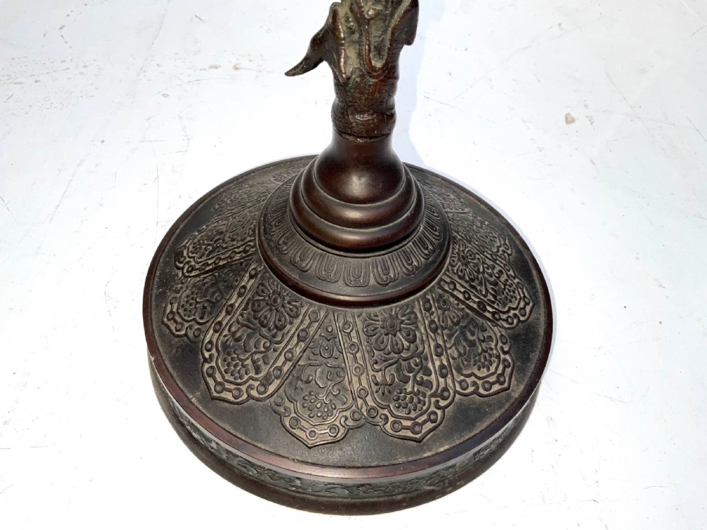 A Victorian dark bronze tabletop dinner gong featuring relief carving and a sculpted figure mounted atop a circular pedestal base. View X
