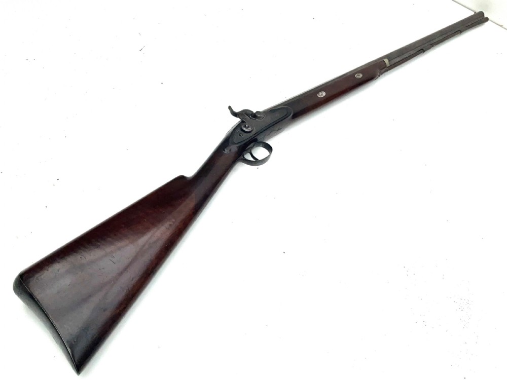An antique nineteenth-century single-barrel percussion fowler featuring a dark polished walnut stock, steel trigger guard, and long smoothbore barrel.