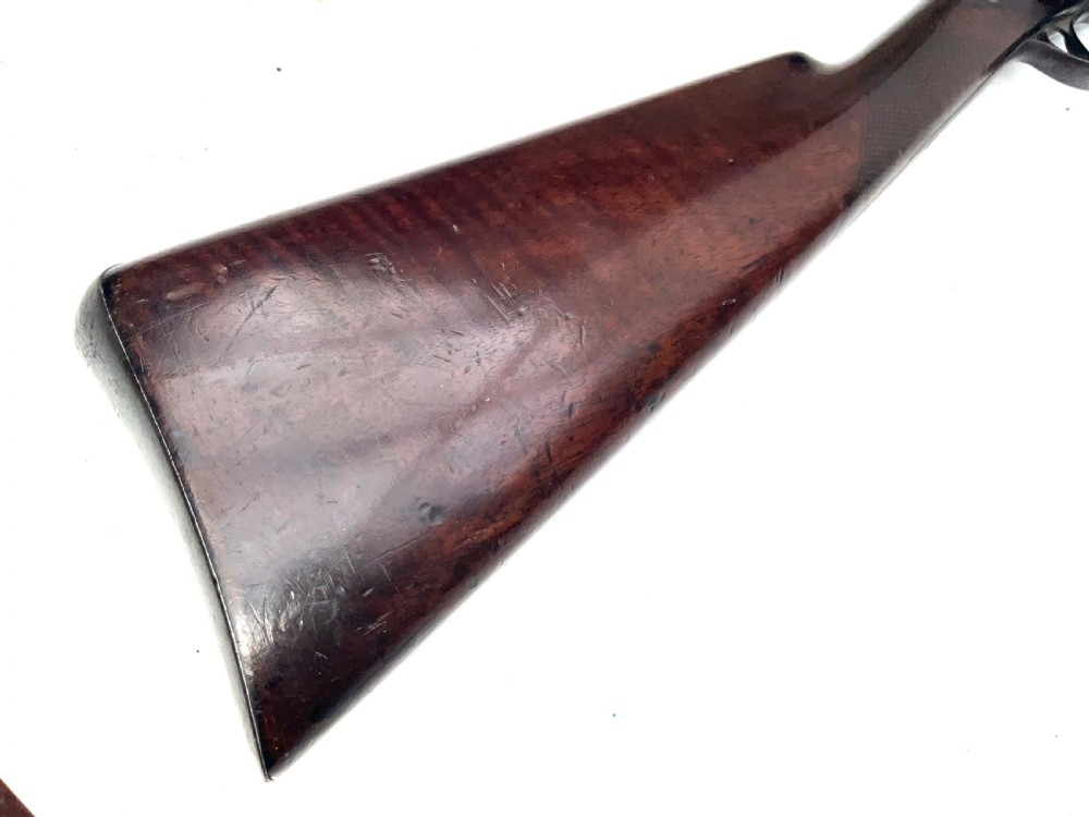 An antique nineteenth-century single-barrel percussion fowler featuring a dark polished walnut stock, steel trigger guard, and long smoothbore barrel. View II