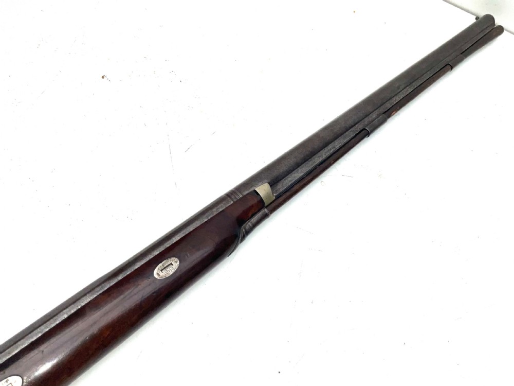 An antique nineteenth-century single-barrel percussion fowler featuring a dark polished walnut stock, steel trigger guard, and long smoothbore barrel. View VI