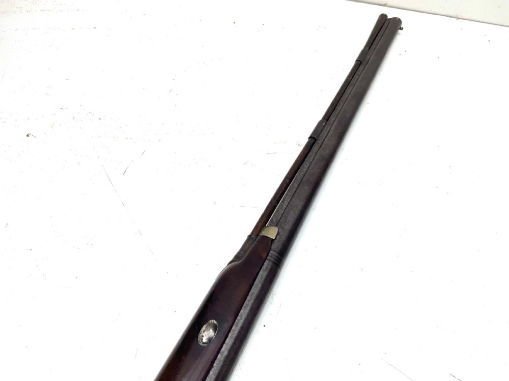 An antique nineteenth-century single-barrel percussion fowler featuring a dark polished walnut stock, steel trigger guard, and long smoothbore barrel. View XI