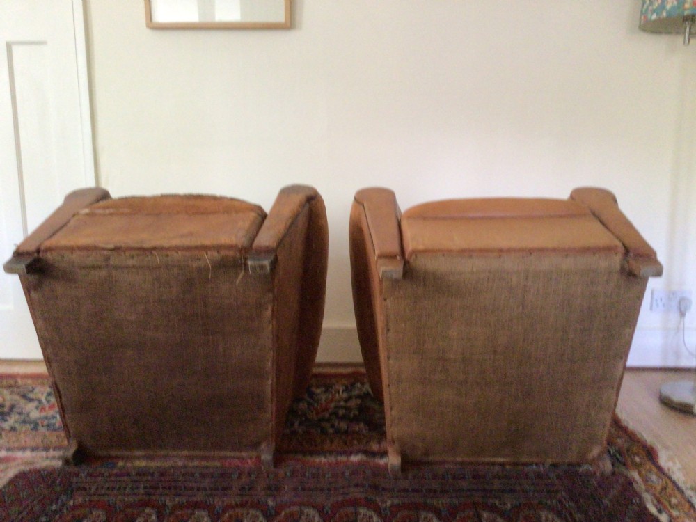 A pair of Art Deco tan leather club armchairs featuring rolled armrests, arched backrests, and aged surface patina. View IX