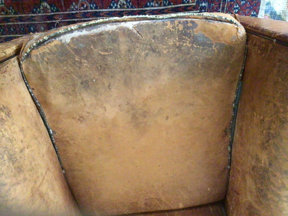 A pair of Art Deco tan leather club armchairs featuring rolled armrests, arched backrests, and aged surface patina. View XII