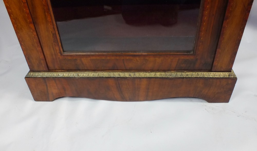 Mid-Victorian figured walnut pier cabinet featuring tulipwood banding, ormolu mounts, and a single glazed door showing velvet-lined shelves. View IV