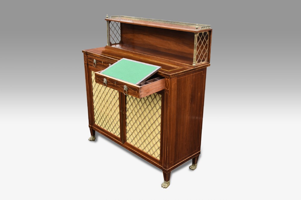 A Regency rosewood chiffonier featuring boxwood inlay, a top shelf with brass gallery and lattice sides, brass grille doors, lion mask handles, and a pull-out fitted writing drawer.