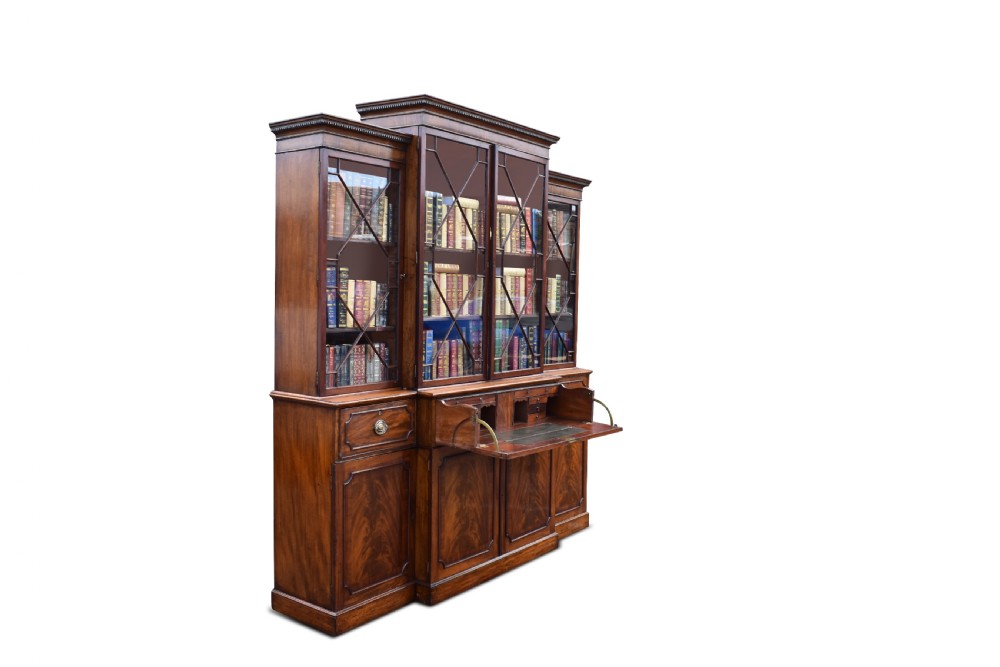 A George III mahogany breakfront secretaire bookcase with geometric astragal glazing, a fitted drop-down writing section, and flame mahogany panel doors. View V