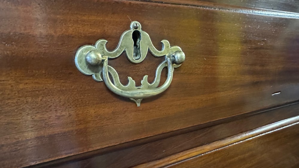 A mid-eighteenth-century Irish mahogany tallboy chest featuring eight graduated drawers with brass swan-neck handles and bracket feet. View V