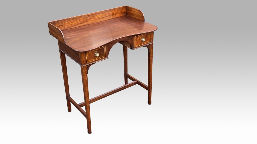 A George III inlaid mahogany dressing side table featuring a raised gallery back, twin drawers, arched kneehole, and square tapered legs with H-stretcher.