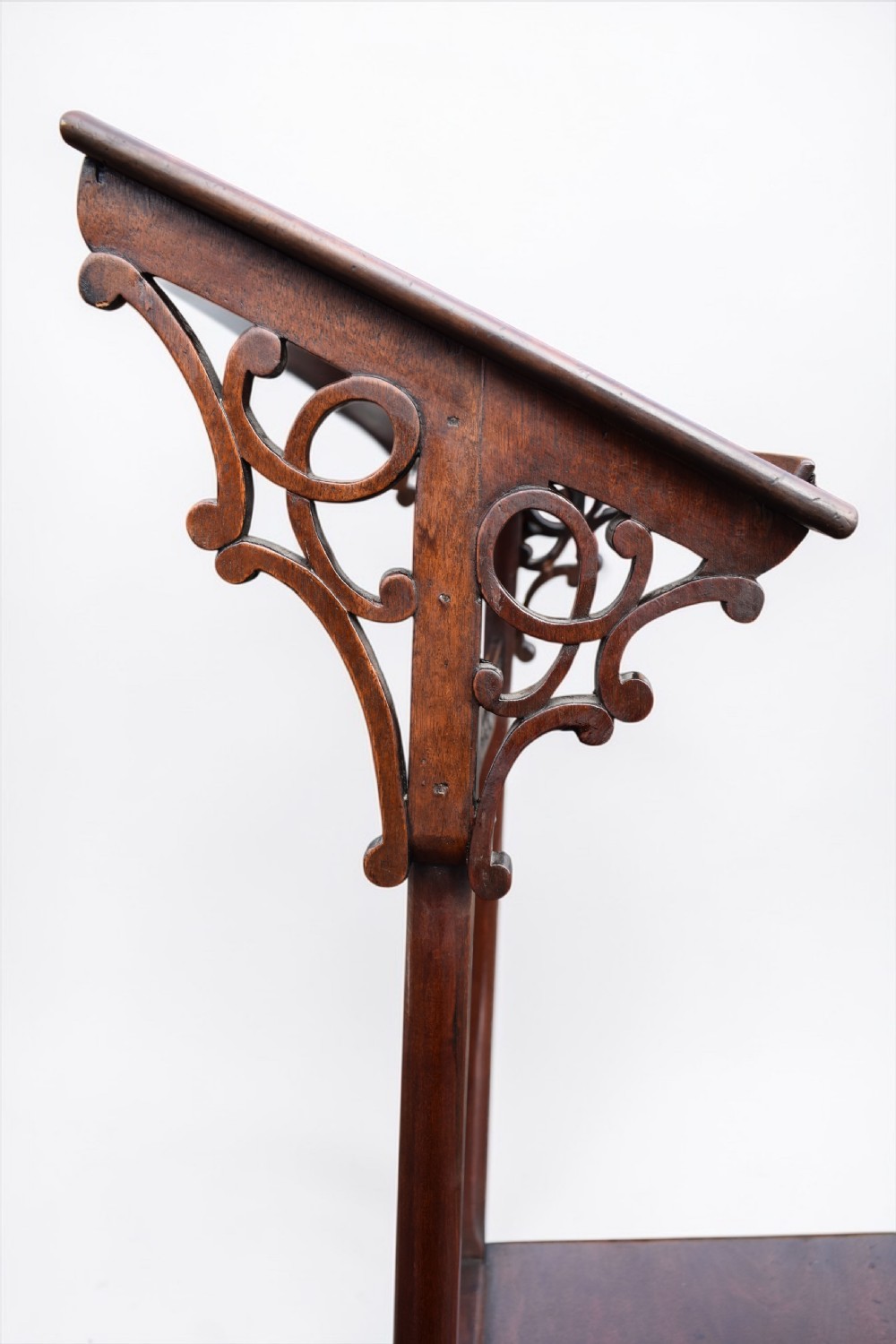 An 18th-century mahogany prie-dieu featuring a slanted top surface, decorative carved pierced fretwork brackets, twin vertical supports, and a flat kneeling base. View III
