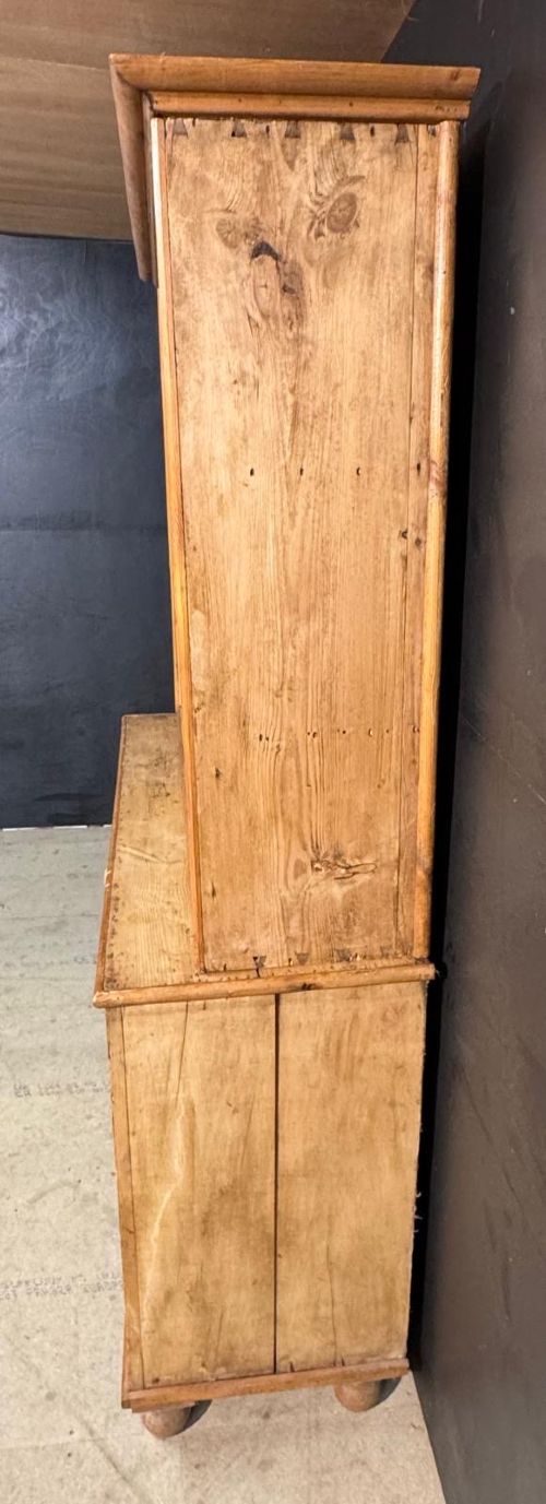 A two-tier warm pine kitchen dresser featuring an upper glazed two-door cabinet with shelves over a lower base containing three central drawers and two side cupboards. View IX