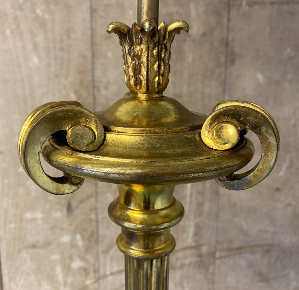 A French brass standard lamp featuring a fluted column shaft, scroll tripod base, and a white opal glass shade. View V