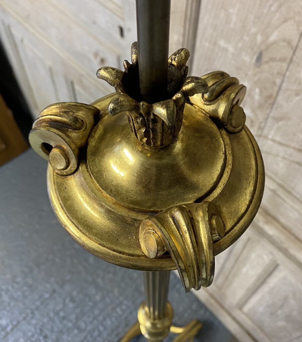 A French brass standard lamp featuring a fluted column shaft, scroll tripod base, and a white opal glass shade. View VI