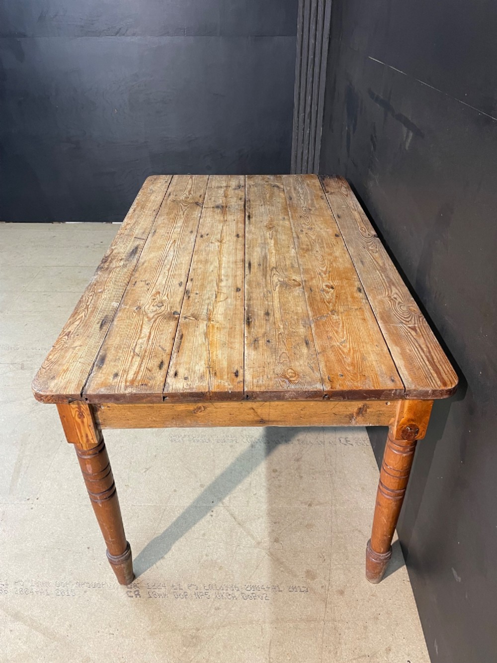 A rectangular pine farmhouse dining table with turned wooden legs and a planked top. View II